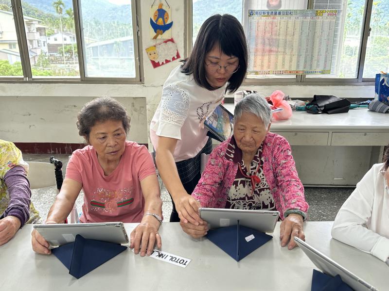 老師指導長輩學員平板拍照後讀取照片的點閱技巧.