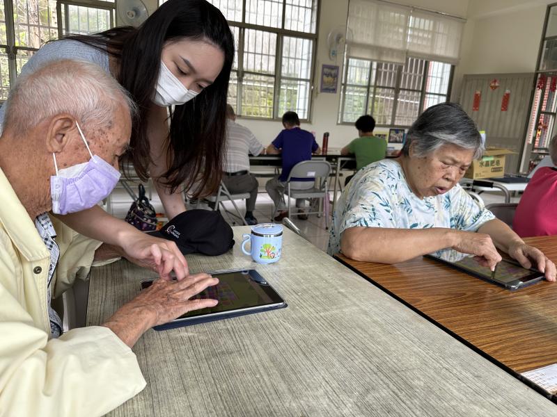 老師在旁協助學員操作平板