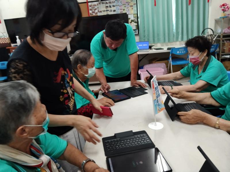 社區理事長及志工協助中高齡長輩學習平板電腦情形