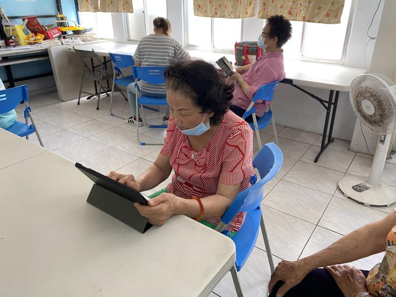 長輩學員摸索健保快易通的APP，瞭解自己就醫紀錄情況。