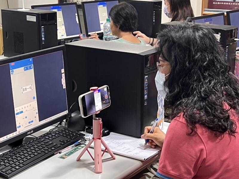 學員一邊使用手機紀錄講師課程，一邊認真抄寫筆記