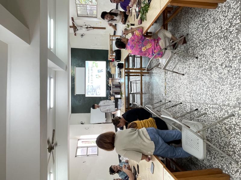 講師與學員們滿懷喜悅地合影留念。在課堂上，講師帶領學員們親手揉搓植物，感受香氣，並利用信義DOC的平板學習如何連接手機網路，進行拍照和植物辨識。學員們在輕鬆愉快的氛圍中，積極互動，學習效果顯著。大家在成功掌握新技能後，興奮地聚在一起拍攝大合