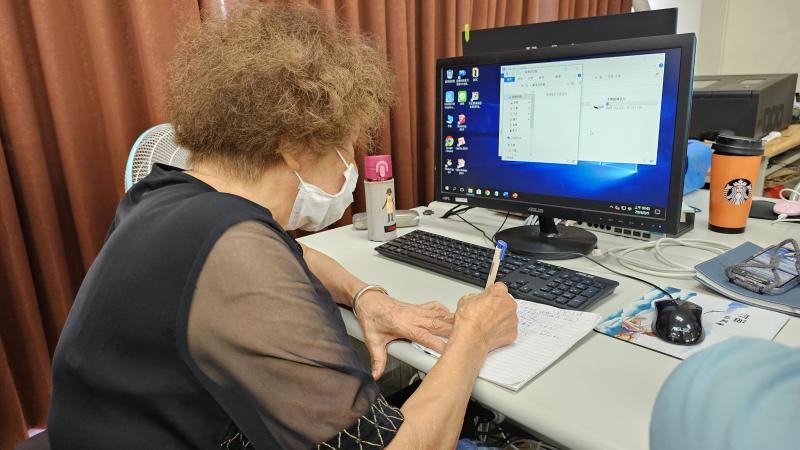 八十歲的學員學習與電腦相處。