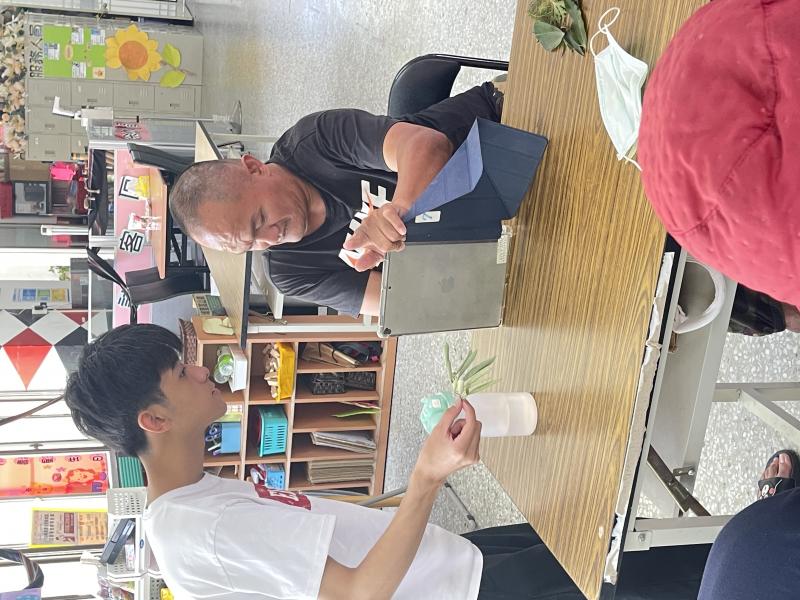 在課程中,壯年身障者學習操作平板,數位小幫手耐心指導,幫助使用植物辨識軟體。雖然長者們不熟悉操作介面,但在數位小幫手的協助下,他們逐步掌握了基本拍照功能。