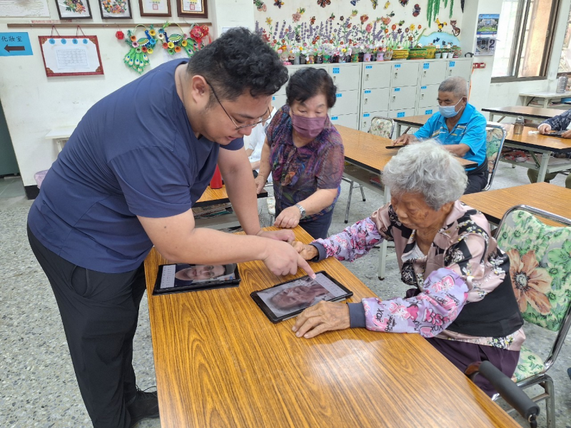 除了大螢幕投影示範,講師也會走到學員們身旁,耐心地指導有問題的每一位長輩如何使用平板進行修圖操作,讓長輩學習著如何讓照片中的自己變得更年輕、更有光彩。