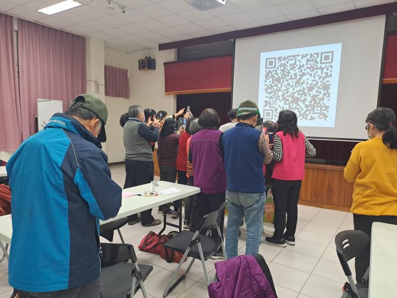 老師教學員如何申請虛擬健保卡、學員們認真拿手機在掃QR Cide