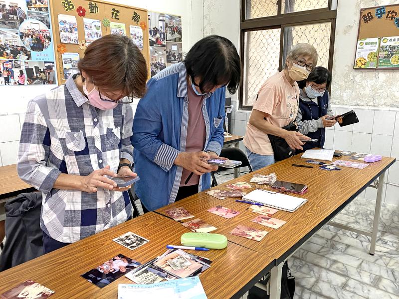 學員們起身調整角度，練習運用老照片修復APP，將桌面上一張張珍貴的老照片翻拍數位化，為記憶留下清晰新貌。