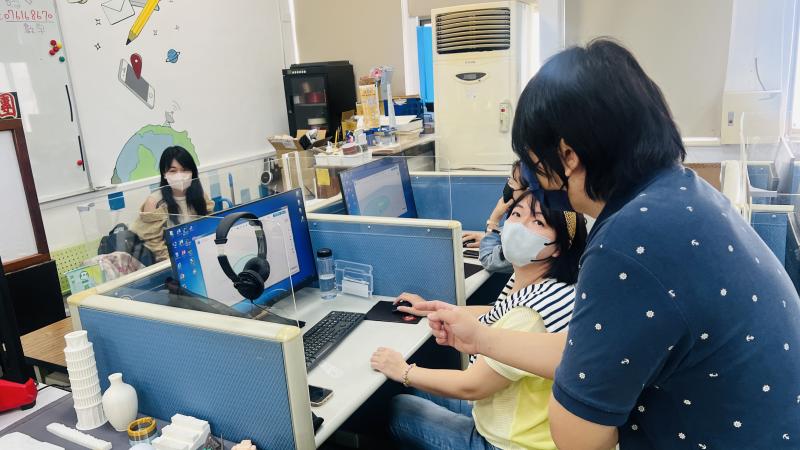 照片中老師與同學認真討論課程中的問題