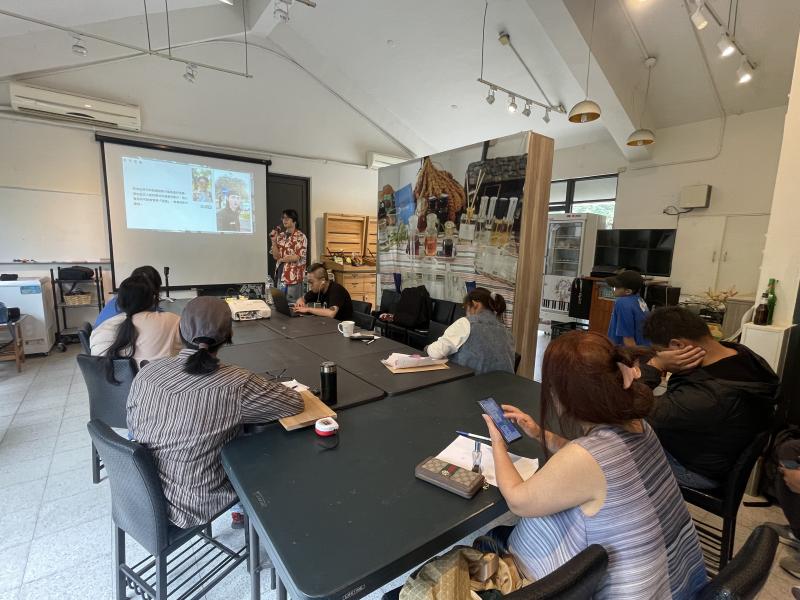 室內課程中，講師以投影片講解如何收集主題靈感，並介紹流行話題模仿與調整。課程內容包括人設參考、影片情境設計，以及常見拍攝角度與剪輯流程說明。學員們一邊聽講，一邊實際操作手機應用程式，提升理論與實作結合的能力。