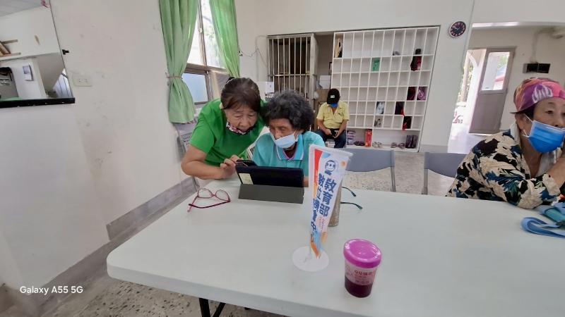 數位小幫手用心指導長輩操作平板工具，使用影音平臺搜尋健康照護影片，長輩認真學習，專心聽助教指導。