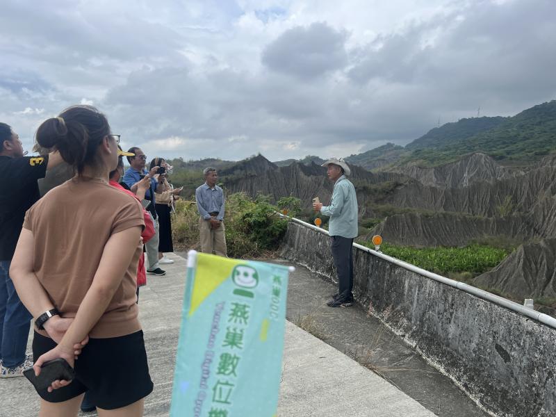 合作單位的伙伴正在解說惡地的形成由來，每位同學拿著手機拍多個角度拍攝與錄影