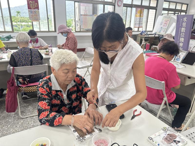 老師指導學員自拍列印出來並裝入相框中，再以鋁線折出造型及點綴珠子、彩色石頭做為外框裝飾.