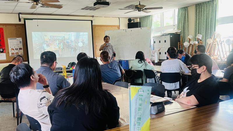 照片中老師用手機投射在熒幕上教大家如何在拍攝中利用光線結合身邊的事物帶來的美感