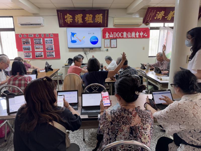 學員正在使用平板電腦學習數位工具，「設計工具 Canva」的簡報進行有關Canva設計工具的教學。學員舉手發問或互動，老師或助教也在旁協助