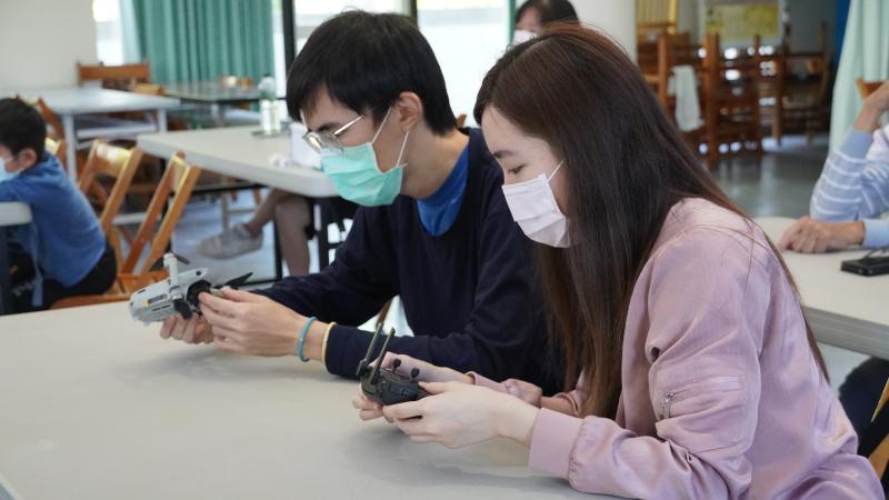 講師一邊說明，學員一邊拿著空拍機與遙控器對照。