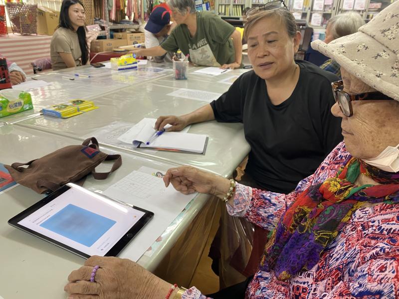 志工協助年長學員操作平板