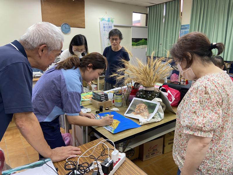 講師教導學員打底後用畫筆作畫封面