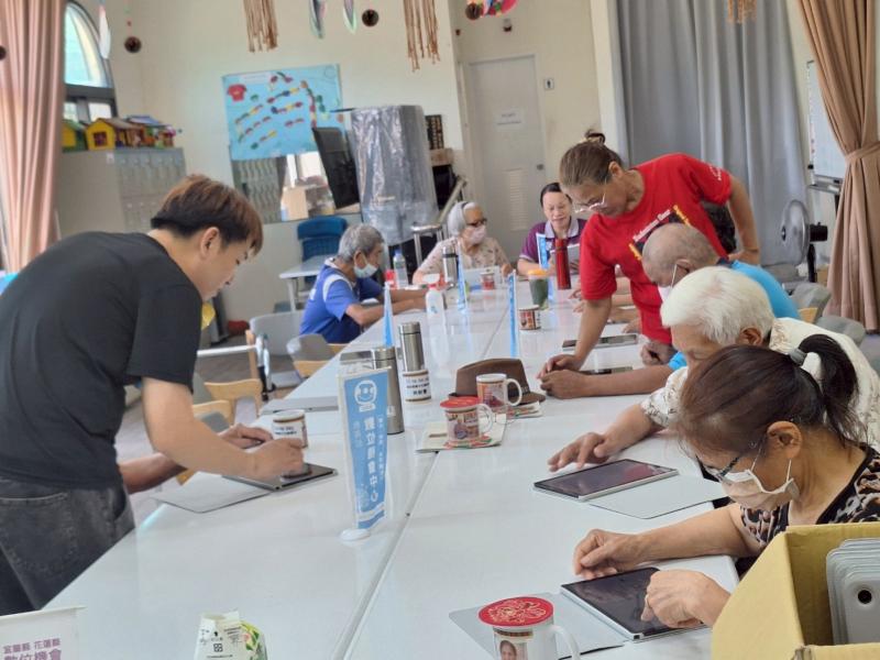 講師和站上服務員協助長者操作平板