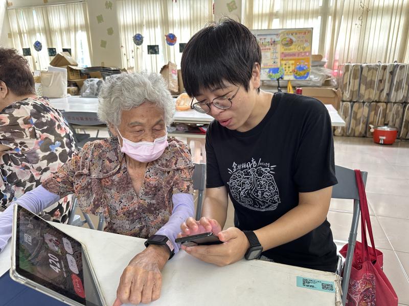 老師協助學員將手環與手機配對