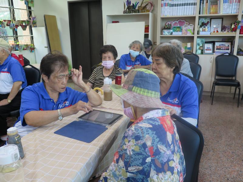 學員分組實際操作平板，互相協助完成任務，現場互動氣氛熱烈。