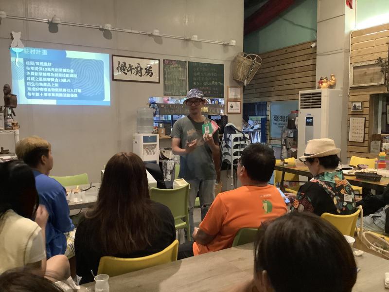 講師手拿電子支付QR code，說明如何申請。