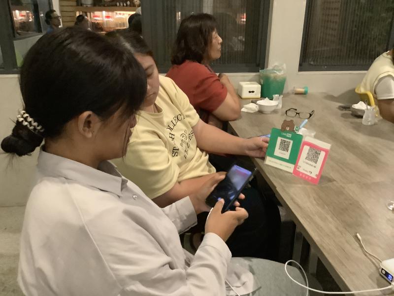 學員拿手機掃描電子支付QR code