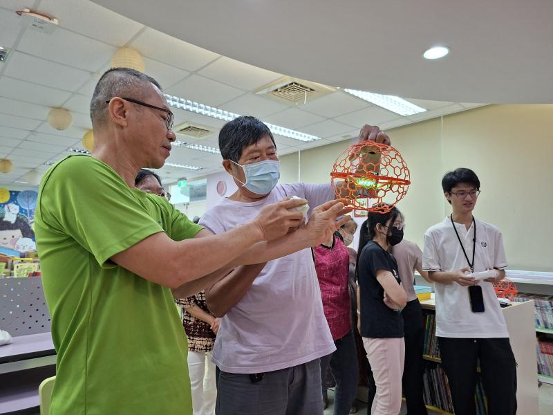 講師在室內以安全的球形無人機，教導學員操控無人機的紀請