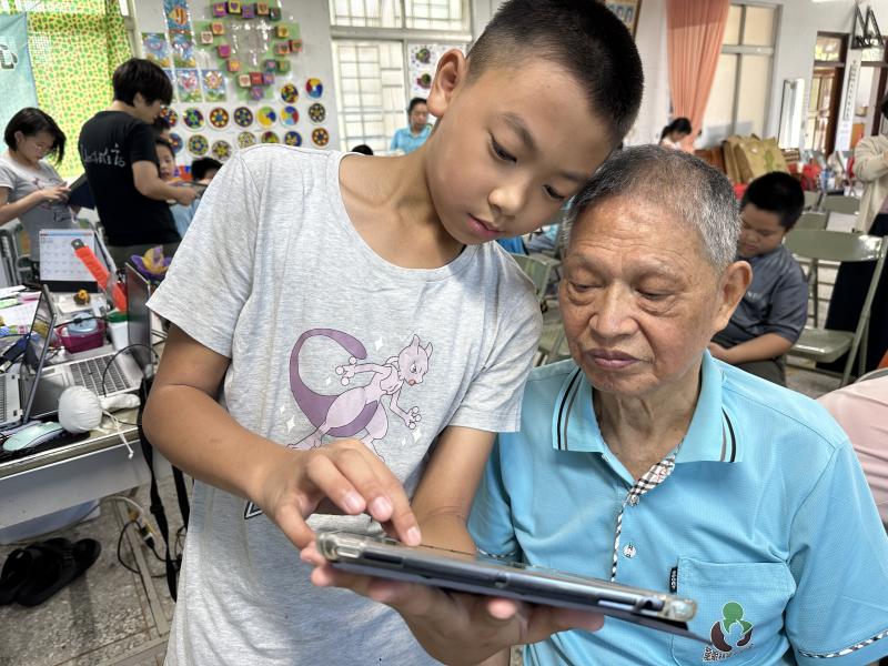 學生與長者一同使用iPad編輯圖片