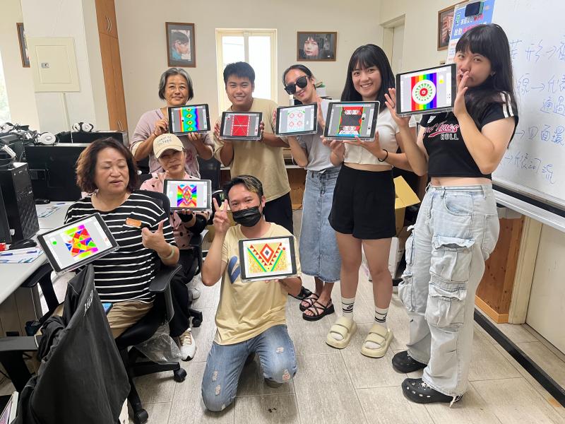學員們手裡拿著親手完成的泰雅圖紋布料設計作品，臉上帶著笑容站在一起合影，記錄下滿滿成就感的時刻。