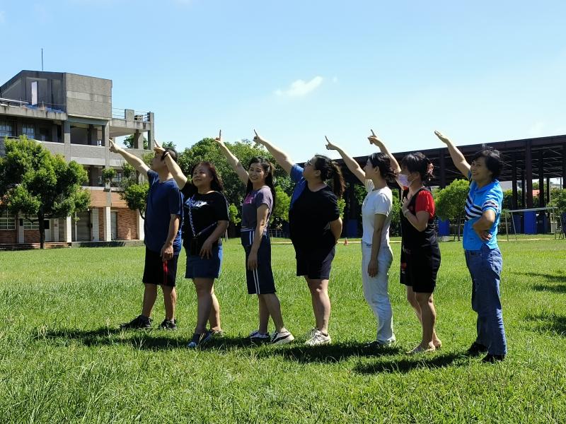 圖為在室外拍攝短影音短片素材，幾個人排成一排，在藍藍的天空下一起指向遠方