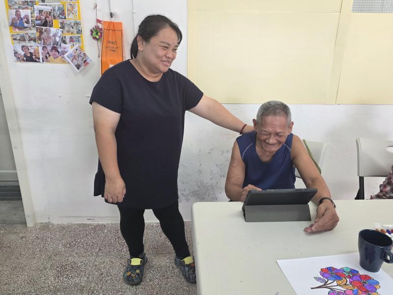 學員看到喜歡的影片，開心地叫志工來分享。