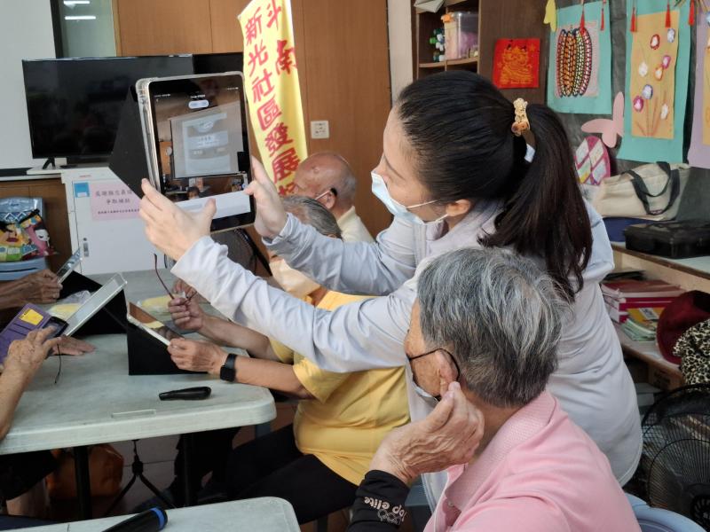 長輩們實際操作平板，學習使用智慧鏡頭辨識身邊的建築與商品。