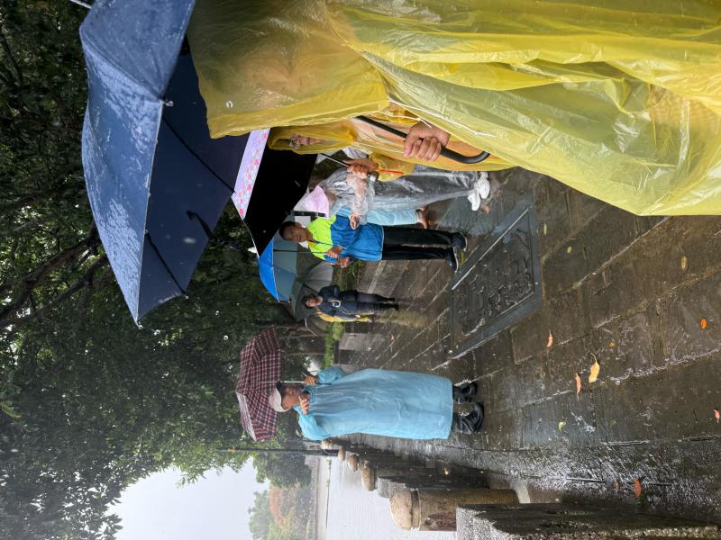 老師在大雨中和學員介紹東安古橋的人文歷史及牛欄河的典故