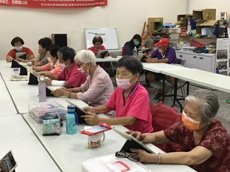 據點長者專心使用平板載具APP應用