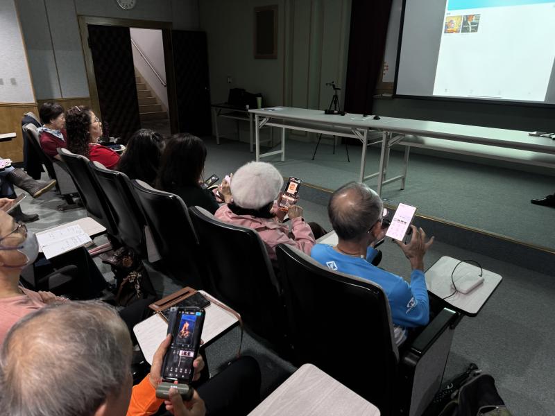 許多學員紛紛拿起手機實際練習，現場氣氛相當熱絡，大家互相討論、交換拍攝心得，展現了濃厚的學習興趣與創作熱情。