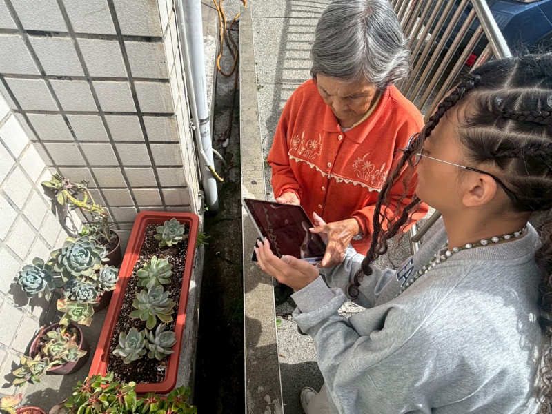 講師正在教導學員如何運用平板中的應用程式（APP）拍攝植物，透過影像辨識了解植物的名稱與特性。