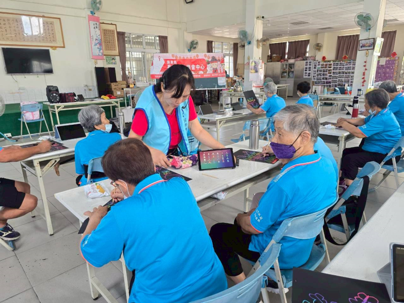 復興社區智慧圖片課程，執行長一對一指導長輩操作平板電腦，學習使用數位工具生成與編輯影像。