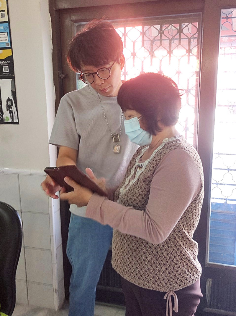 網購小編課程中，講師一對一指導女性學員操作手機介面，協助解決平台設定與操作問題。