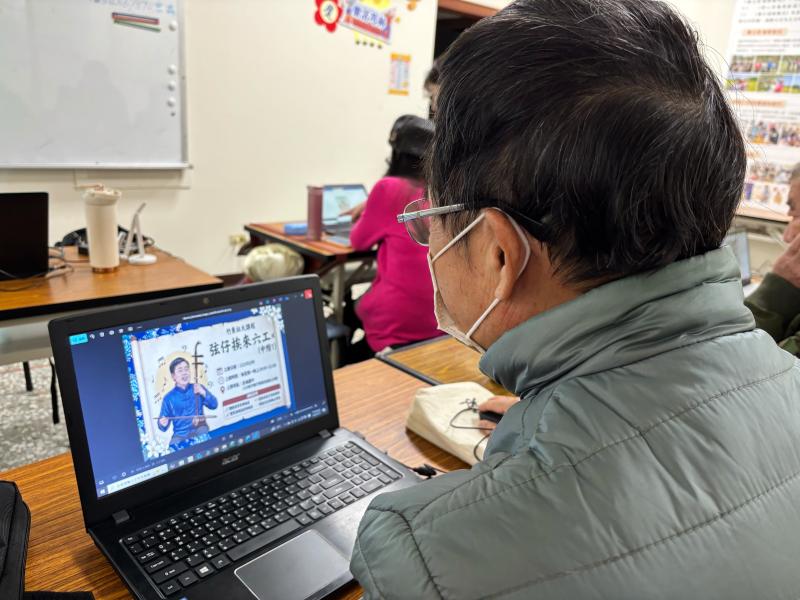 一位教二胡的老師專注地設計他的一頁網，網頁圖卡中包含他拉奏二胡的照片及課程資訊，他將原本傳統的樂藝技能，轉化為數位宣傳內容藉以提升曝光度。