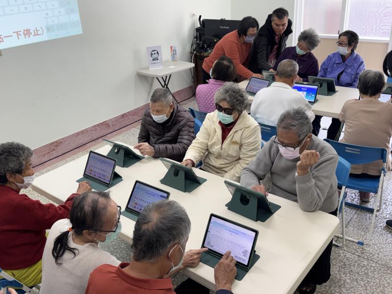 長輩實際用平板做明信片，邊做邊討論，越做越投入，現場氣氛很熱絡。