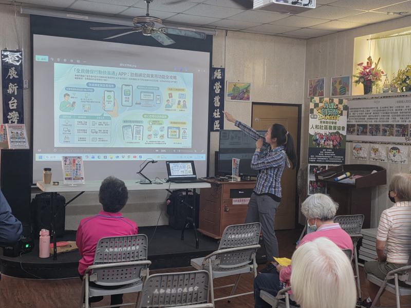 講師指著大螢幕上的「數位全攻略」圖解，向台下銀髮學員逐一介紹健保 App 的各項功能與綁定流程。
