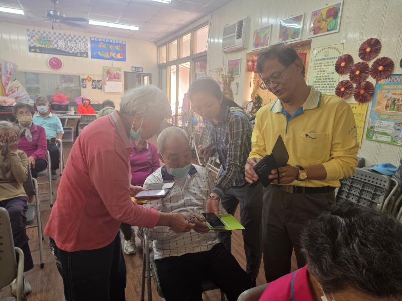 講師下台貼身指導，耐心地帶領長輩實際操作手機螢幕，克服手感障礙，完成數位健康設定。