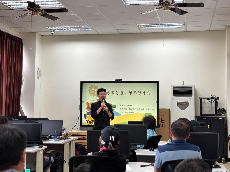 在芎林數位機會中心教室內,講師站在觸控螢幕前講授『共享交通:單車隨手借』課程。教室內有多位學員認真專注地聽講。