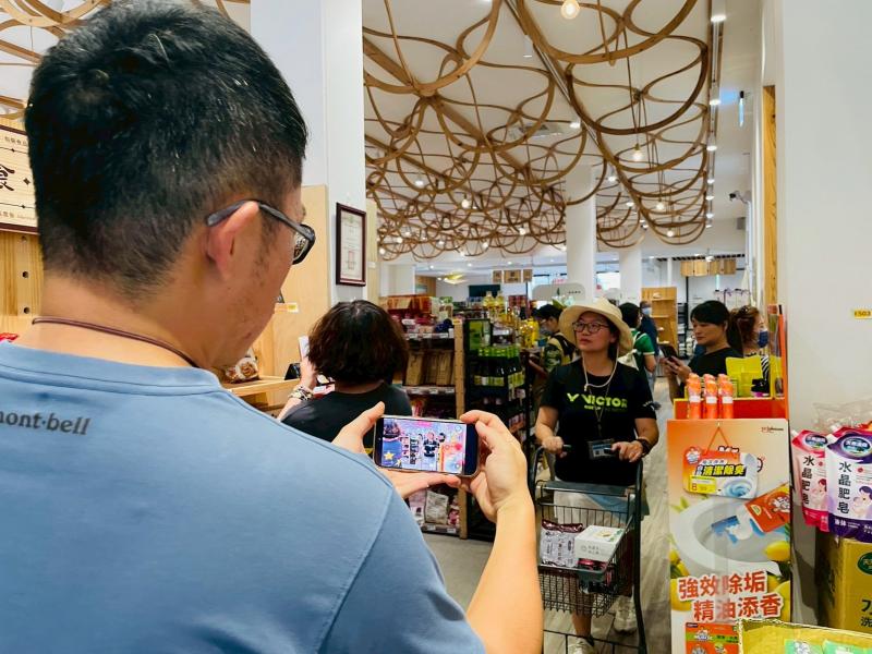 老師親自示範如何舉用手機拍攝，學員認真盯著螢幕學習，把眼前美好風景定格下來！