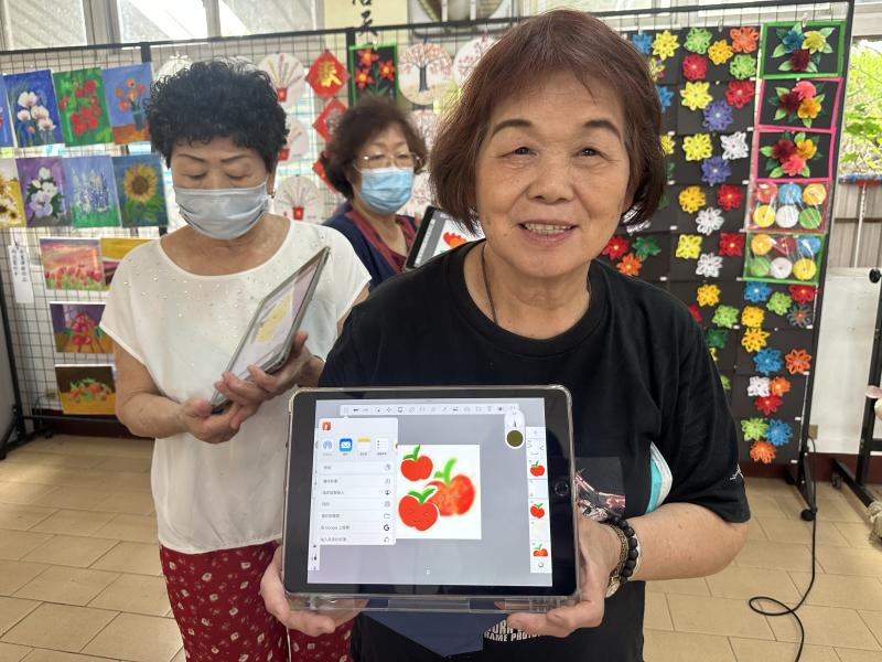 學員拿著平板展示素描彩繪成果.