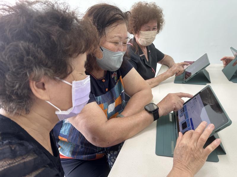 長輩實際操作平板音樂App,彼此討論、互相提醒,從不敢按到願意嘗試,學習氣氛輕鬆熱絡。