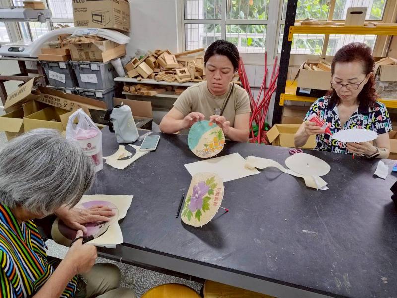 展現細緻的手作功夫！學員們小心翼翼地修剪布面，再認真黏貼到美濃傳統傘骨上，眼神裡滿是專業。