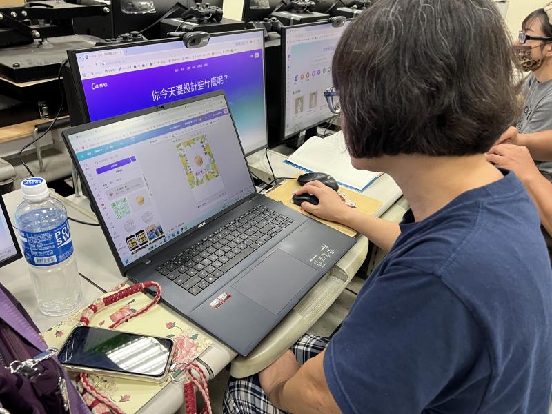 學員專心操作筆電上的 Canva 設計軟體,螢幕顯示水果包裝設計畫面