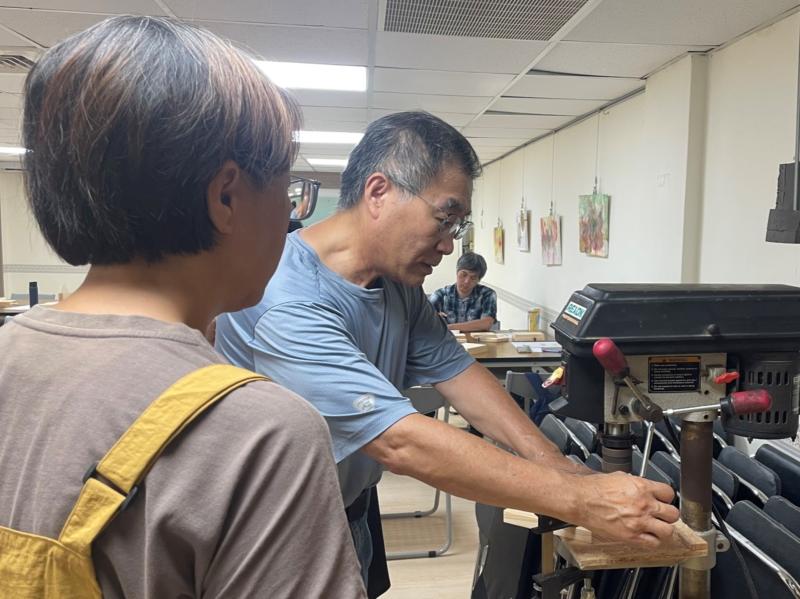 老師悉心指導學員鑽孔,傳遞木工手作溫度