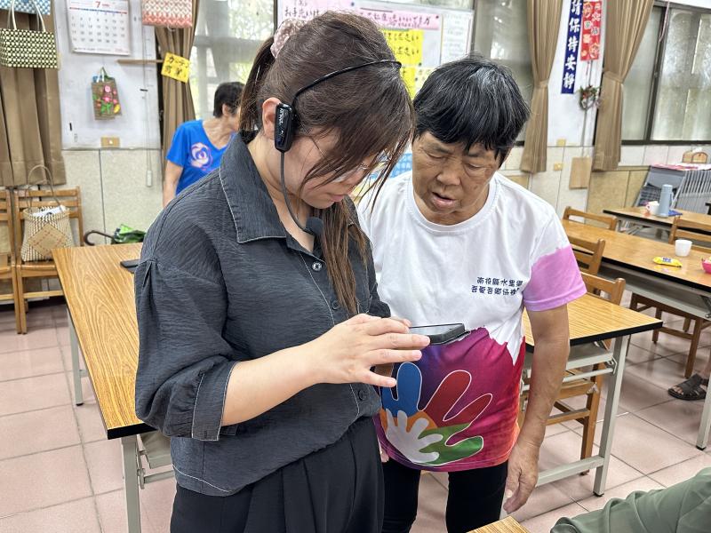 學員拿著手機請老師幫忙查看全聯支付-下載及註冊操作技巧是否正確.